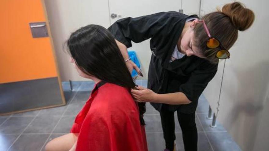 Una adolescente de 15 años, ayer, cortándose el pelo para la fabricación de pelucas solidarias.