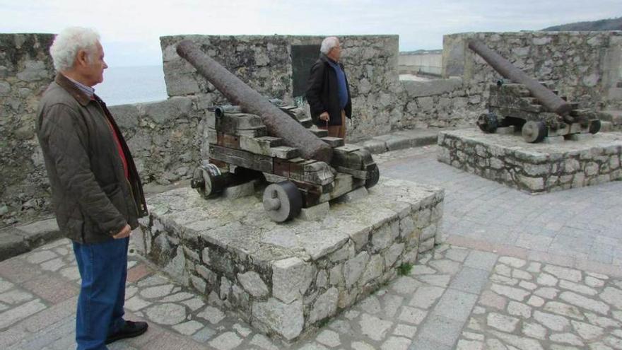 Dos hombres observan los cañones ubicados en El Fuerte de Llanes, ayer.