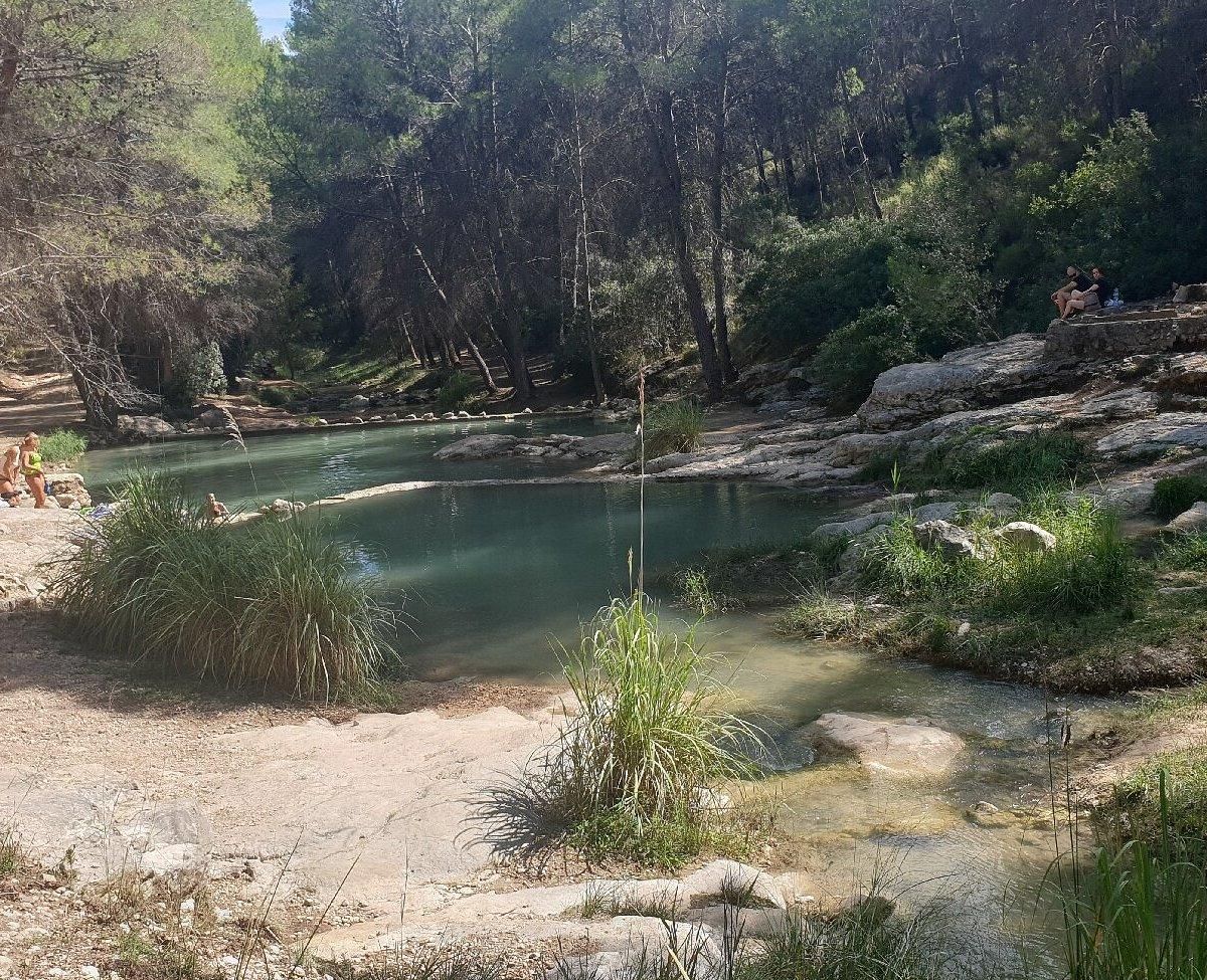 Varias personas se relajan junto a las pozas del Río Alhárabe