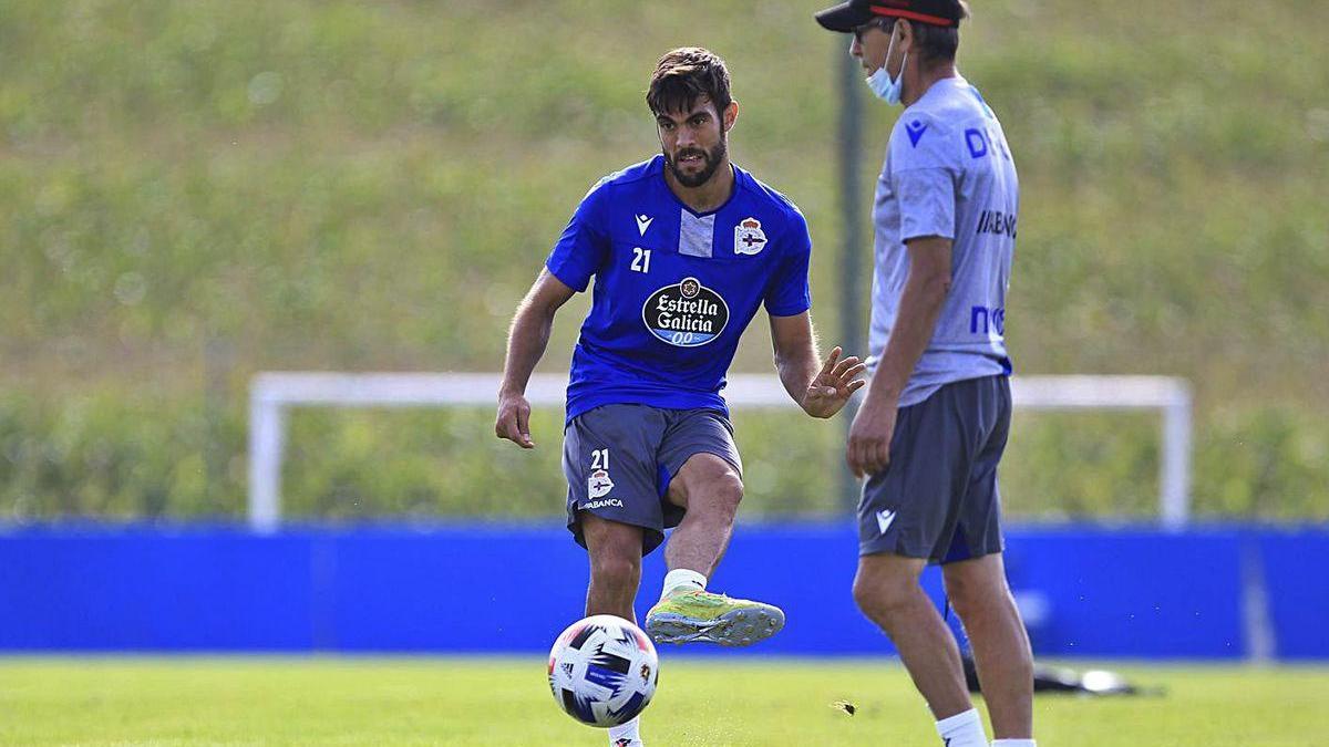 Eneko Bóveda golpea el balón ante Fernando Vázquez, ayer en Abegondo.