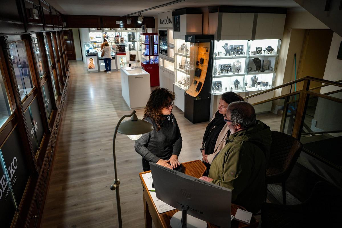Clientes observan y seleccionan piezas en el interior de la joyería.