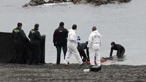 Agents de la Guàrdia Civil retiren el cos del subsaharià trobat avui a la platja del Tarajal de Ceuta.