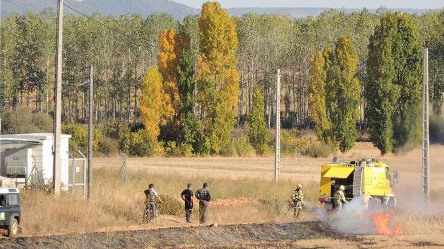 Una carroceta con con bomberos sofoca uno de los fuegos declarados ayer.