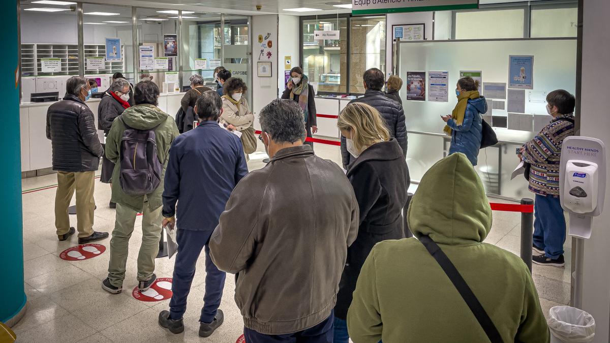 Pacientes hacen cola para realizarse test de antígenos en un centro de salud de Barcelona.