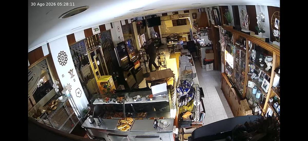 En el centro de la imagen, el asaltante, antes de arremeter contra la tragaperras, en una grabación de seguridad.