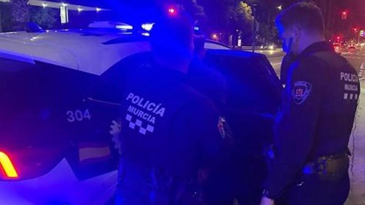 Agentes de la Policía Local de Murcia, junto a un vehículo del cuerpo.
