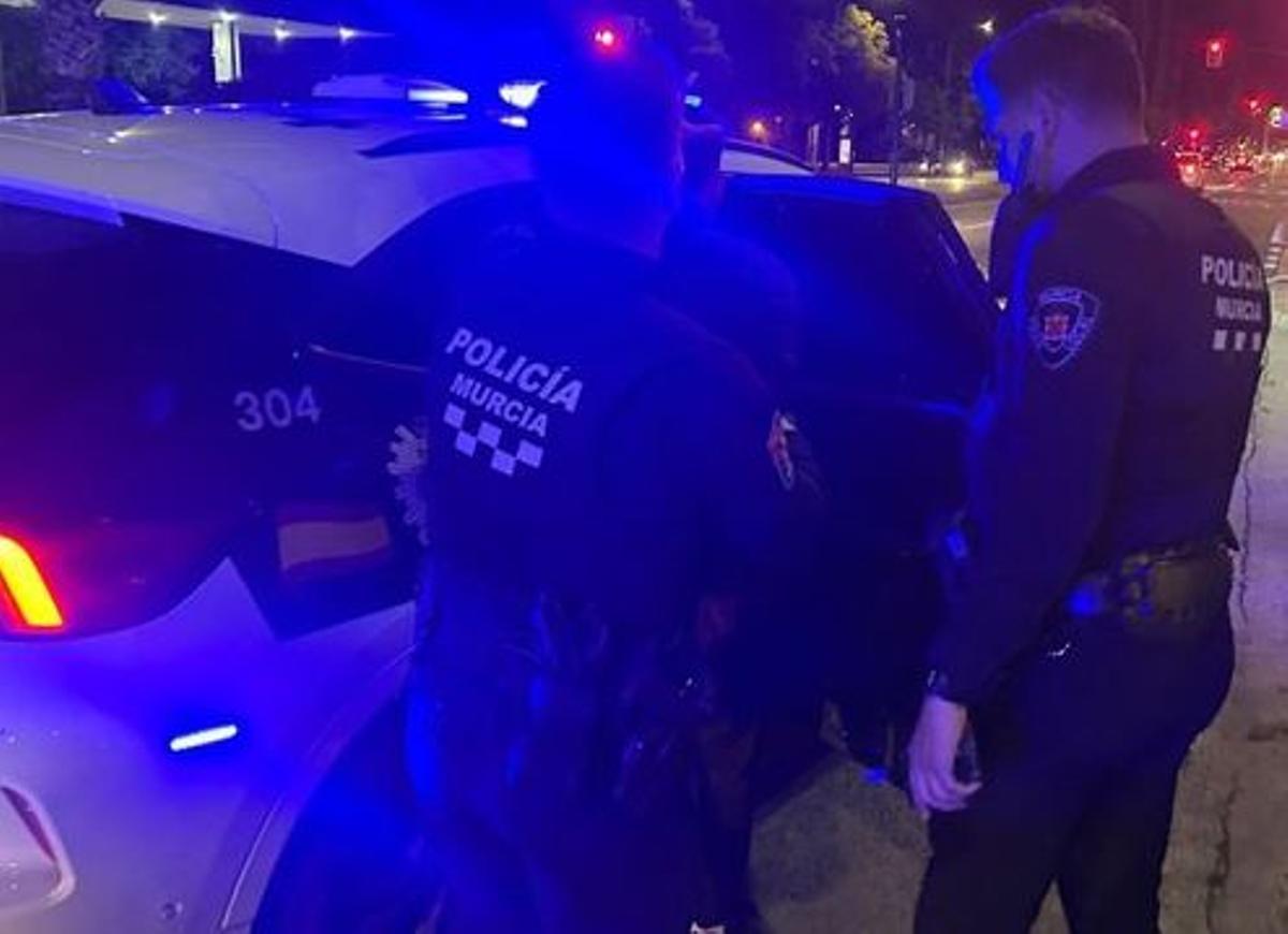 Agentes de la Policía Local de Murcia, junto a un vehículo del cuerpo.