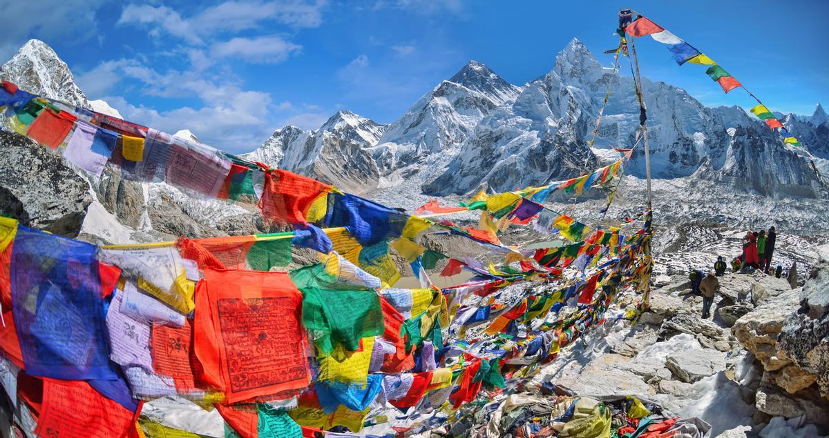 Vista del Monte Everest en un campo base repleto de banderas.