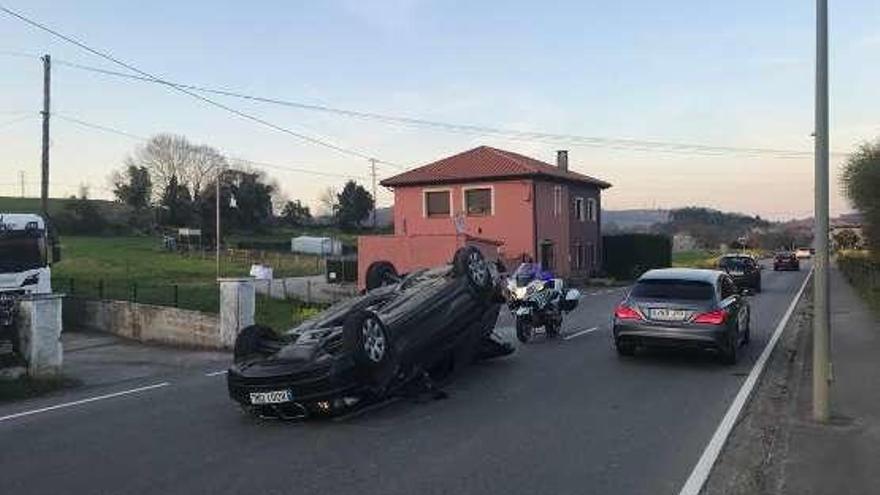 El coche volcado tras el impacto en la AS-115.