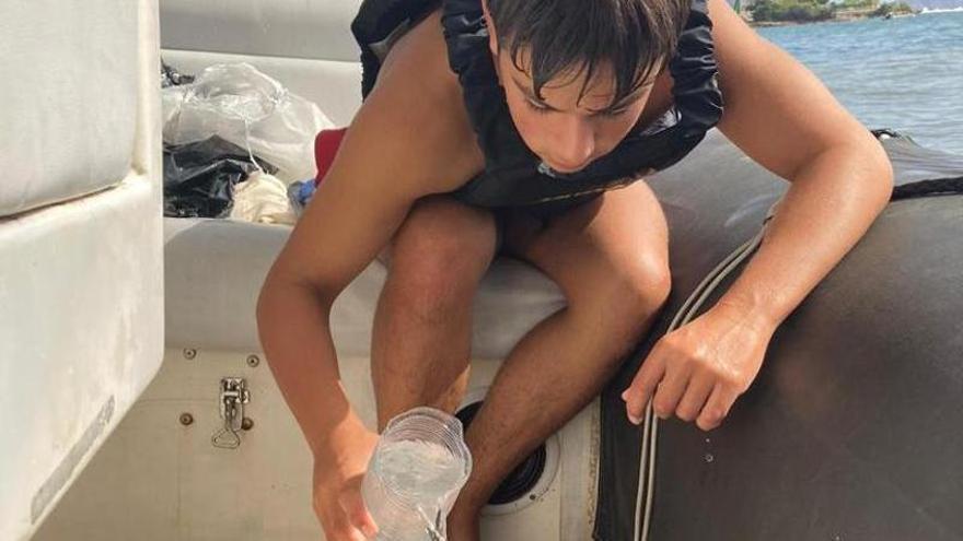 Uno de los jóvenes regatistas del Club Náutico Ibiza atiende a la tortuga rescatada.