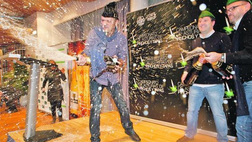 Martino descorcha sidra junto a Pepe Ron y Rodrigo Roza, los tres galardonados en el V Concurso de Pinchos de Asturias.