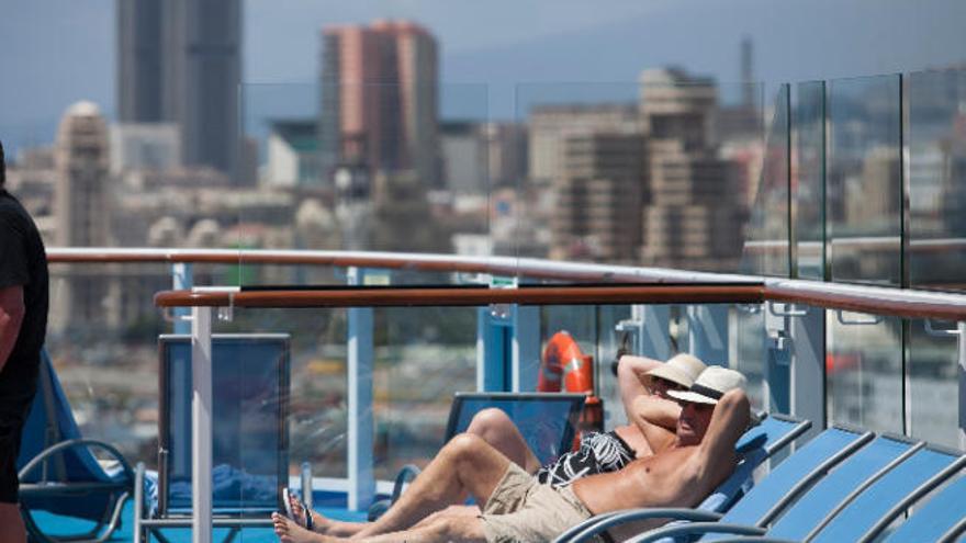 Dos turistas toman el sol en un crucero en Santa Cruz de Tenerife.