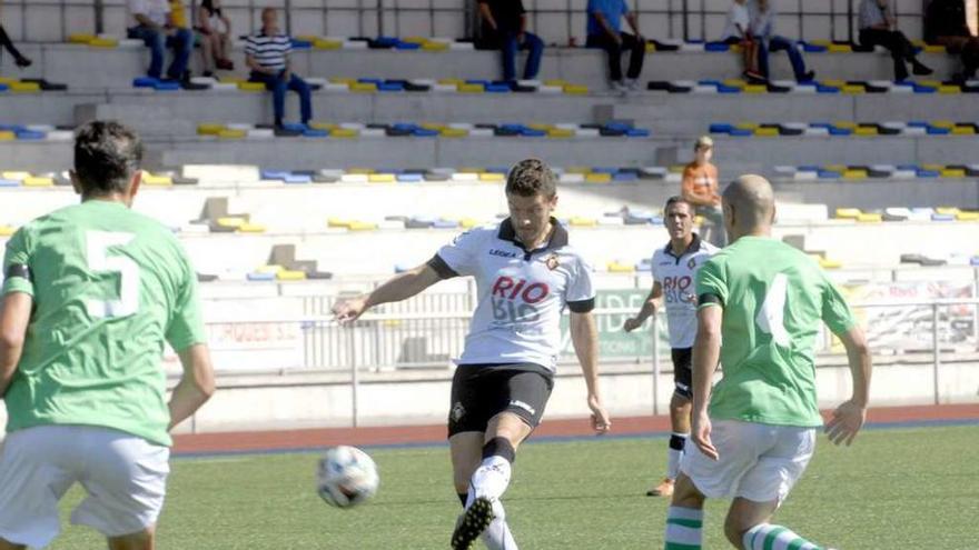 Samuel realiza un pase entre los llaniscos Toyos, izquierda, y Aitor Tornavaca en el duelo del pasado curso disputado en Mieres.