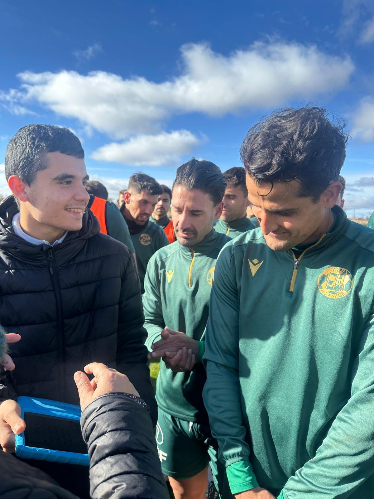 Un joven conversa con uno de los futbolistas.