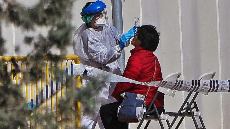 Una sanitaria realiza un test de coronavirus en el exterior de un hospital.