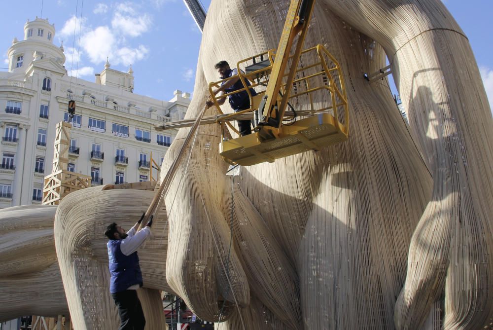 Los trabajadores del taller del artista fallero Manolo García preparan el izado de una de las piezas de la Falla de la Plaza del Ayuntamiento.