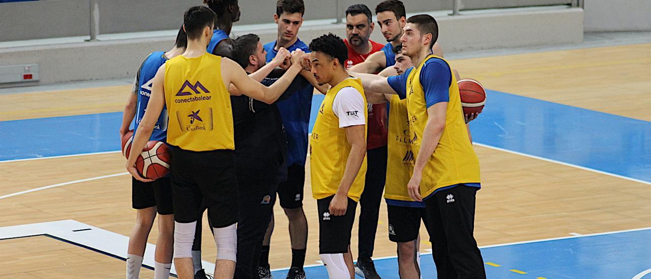 Los jugadores del Palmer Palma chocan sus puños con los técnicos tras la sesión.