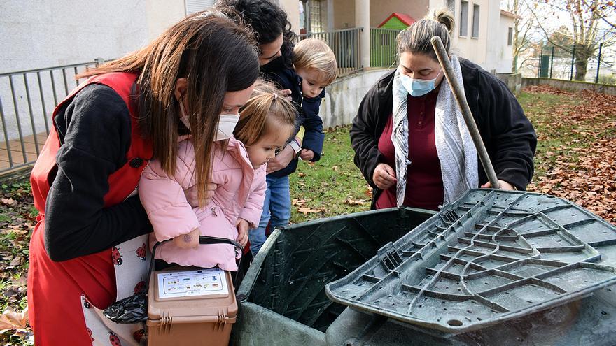 La maestra compostera y las profesoras muestran a los niños el interior de uno de los colectores.