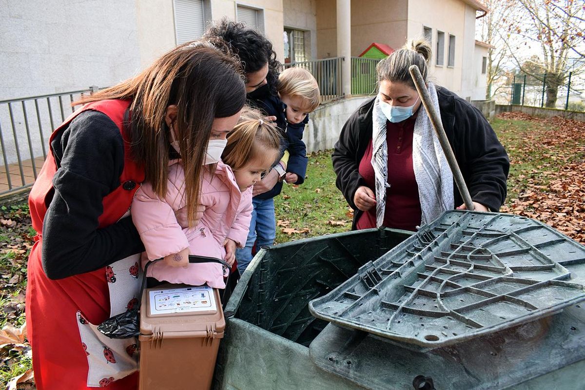 La maestra compostera y las profesoras muestran a los niños el interior de uno de los colectores.