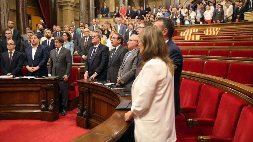 Los miembros del Govern y los diputados de Junts pel Sí y de la CUP (con el puño en alto) cantan &quot;Els Segadors&quot; tras la aprobación de la ley.