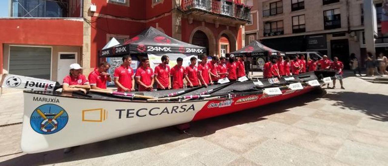 Integrantres del Club de Mar de Bueu con su trainera en la Praza do Concello. |  // SANTOS ÁLVAREZ