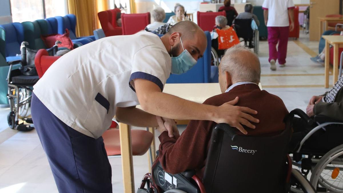 Un trabajador de una residencia de mayores de Córdoba atiende a un usuario.