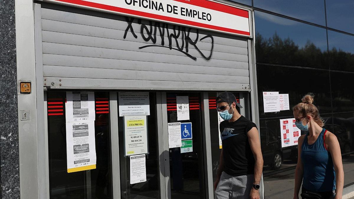 Dos jóvenes pasan ante una oficina de empleo en Madrid, el pasado 5 de mayo