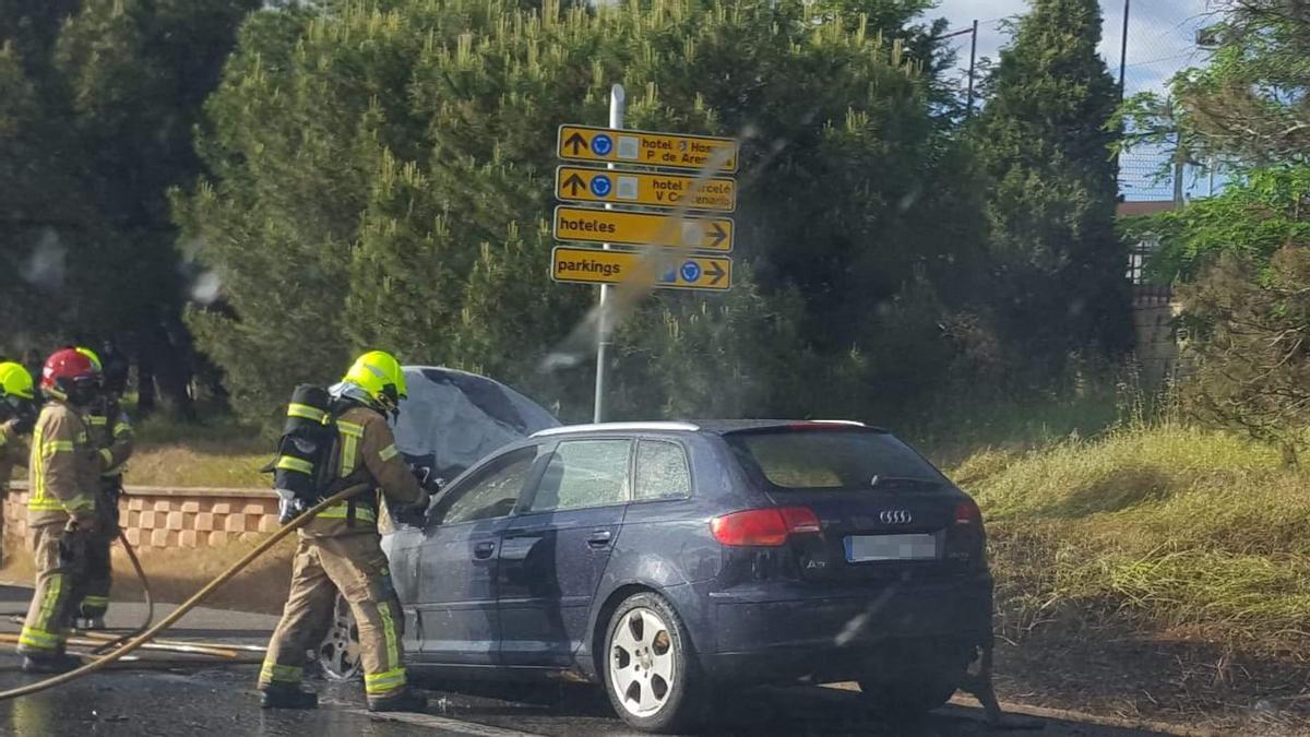 Efectivos extinguen el fuego en el vehículo este viernes.