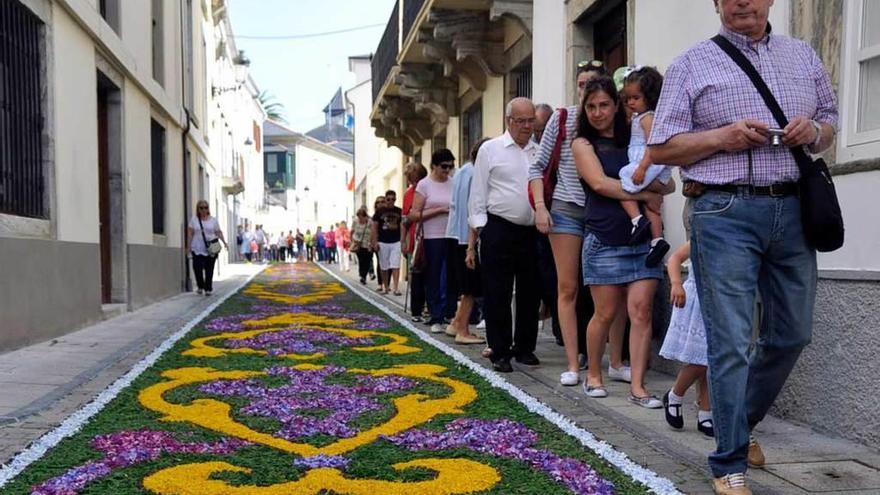 Los visitantes contemplan y toman fotos de las alfombras florales de Castropol.