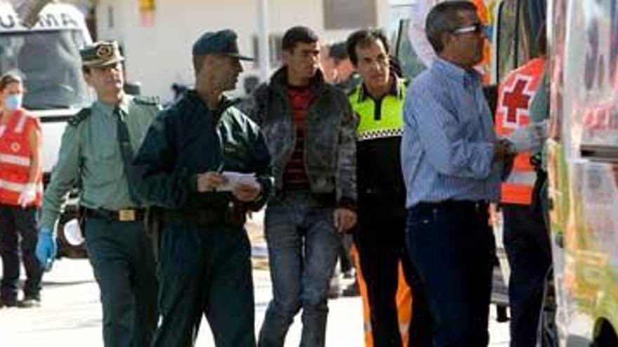 Agentes de las fuerzas de seguridad y personal de los servicios sanitarios atienden a su llegada al muelle pesquero de Calpe, a los inmigrantes que fueron localizados a bordo de una patera a unas 40 millas al este del puerto de Alicante, uno de los cuales requiere asistencia sanitaria.