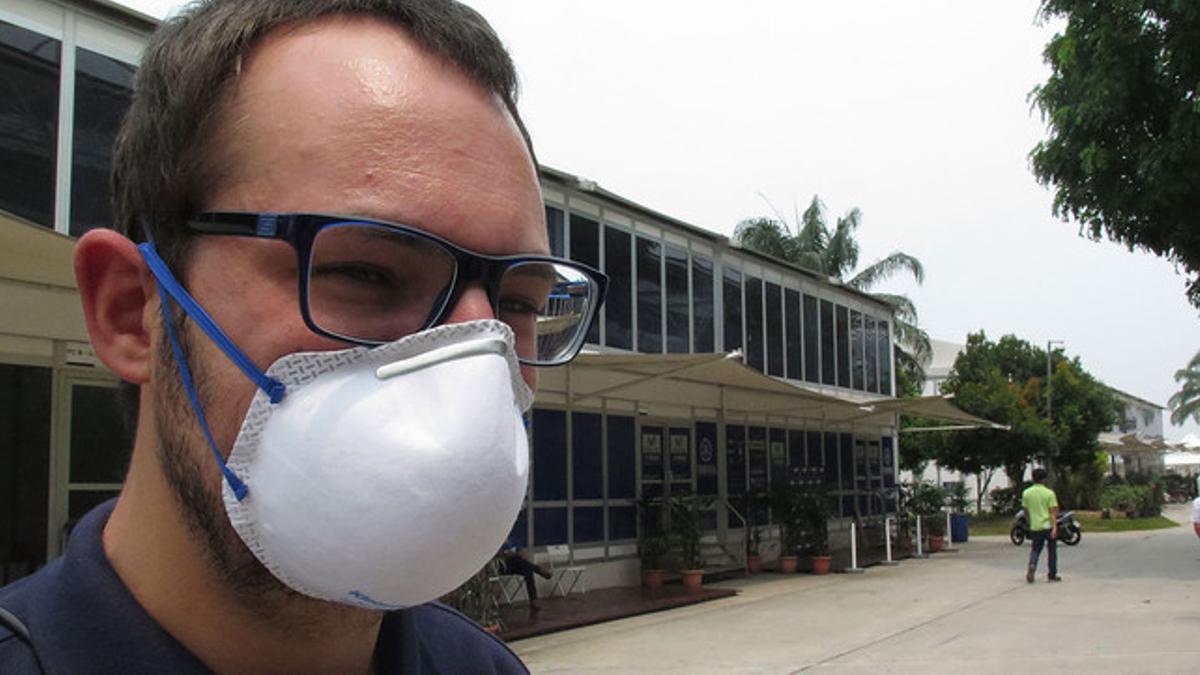 Un trabajador del  Dorna, organizadora del Mundial de motociclismo, con una mascarilla para protegerse de la nube tóxica que flota sobre Malasia