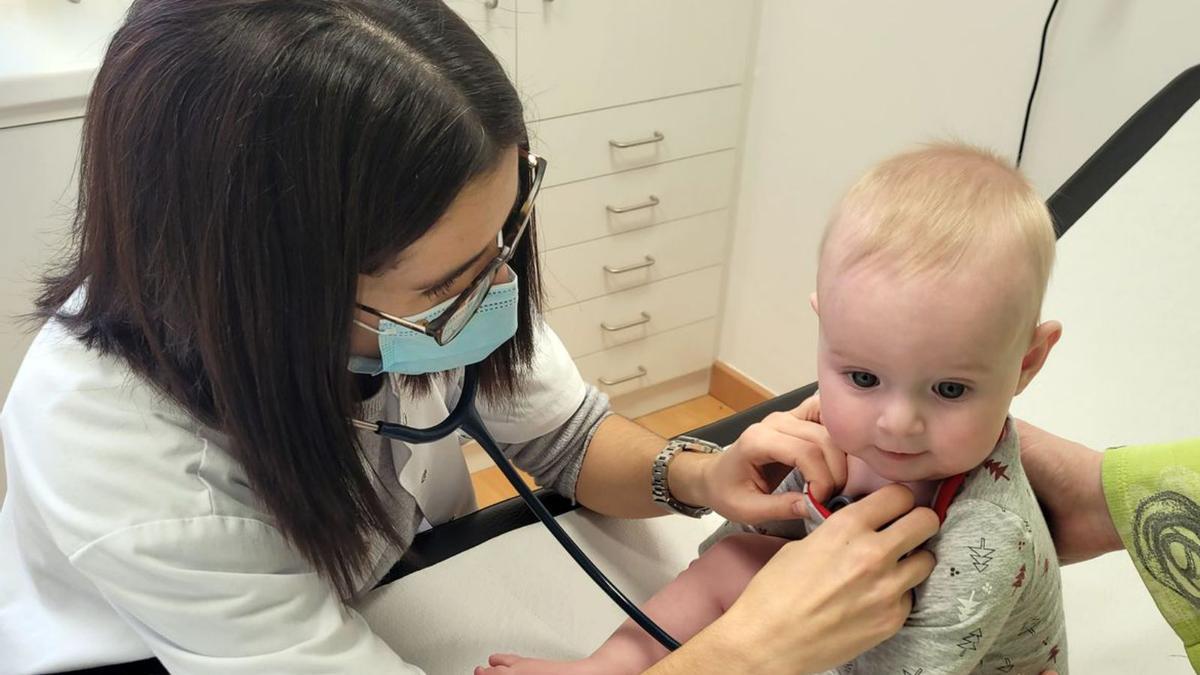 Una pediatra atén un nadó en una consulta