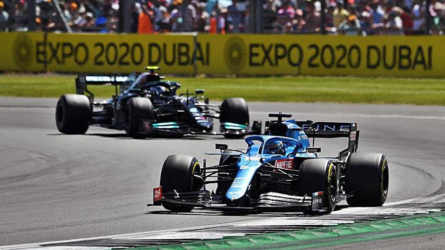 Fernando Alonso, en primer plano, ayer en el GP de Gran Bretaña.  | EFE/ANDY RAIN