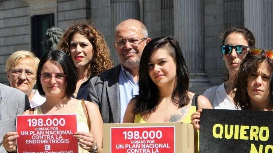 Eva García, a la izquierda, sostiene un cartel frente al Congreso.