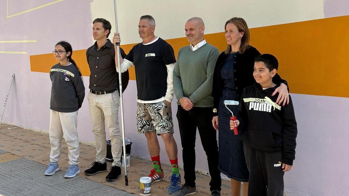 El artista, los niños y los responsables municipales al comienzo de la pintura