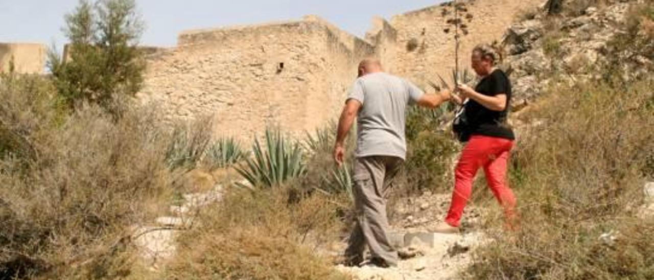 Un hombre ayuda a su mujer a cruzar entre los escalones que en su origen se diseñaron para facilitar el paseo y que ahora apenas se diferencian de la propia ladera del monte