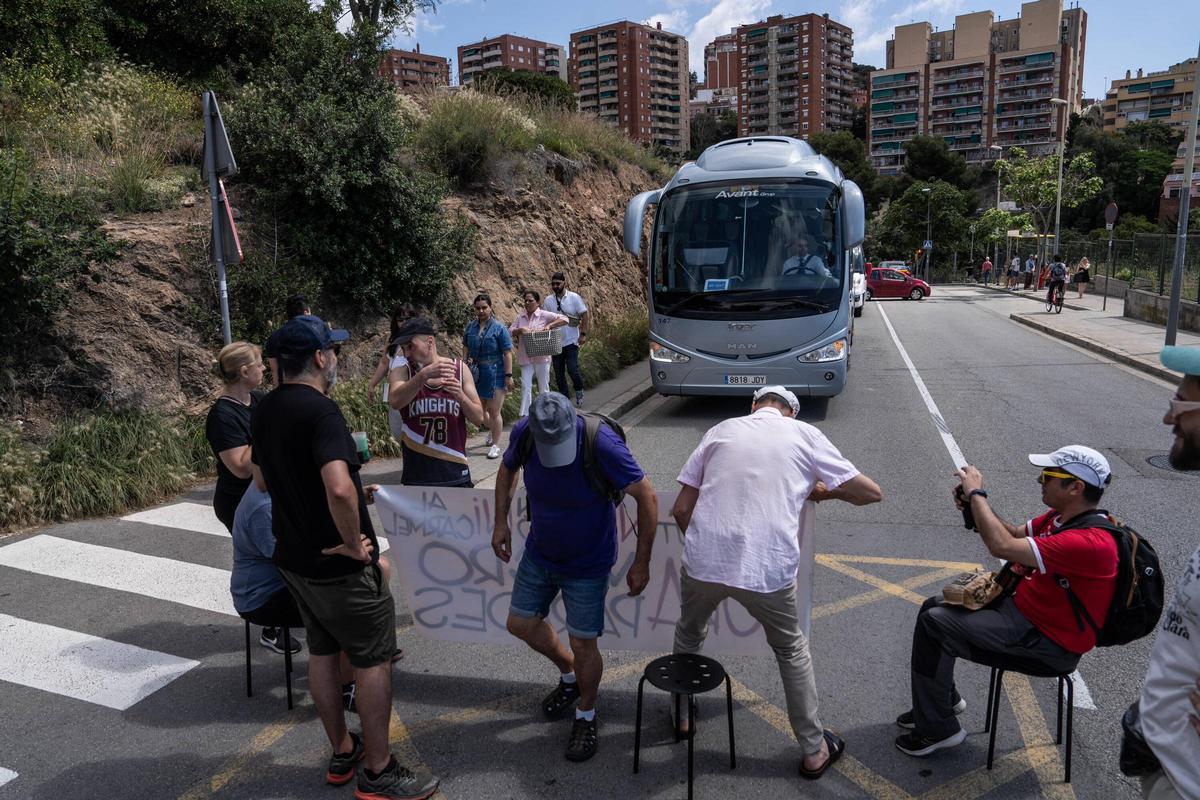 Unos manifestantes interrumpen el paso a un autocar de un touperador en las inmediaciones del Park Güell, en Barcelona.
