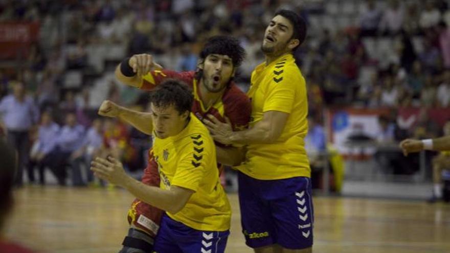 El jugador del Juanfersa Grupo Fegar Maxi Cancio, entre dos jugadores del Bidasoa, tras un disparo.