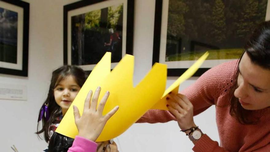 Izíar Sánchez, probando la corona a una niña durante el taller.