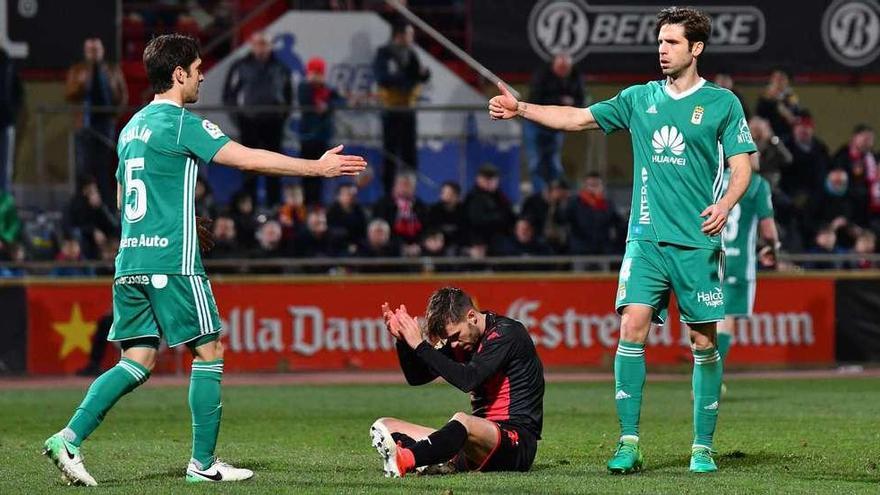 Forlín y Verdés se felicitan con el delantero del Reus Fran Carbia en el suelo.