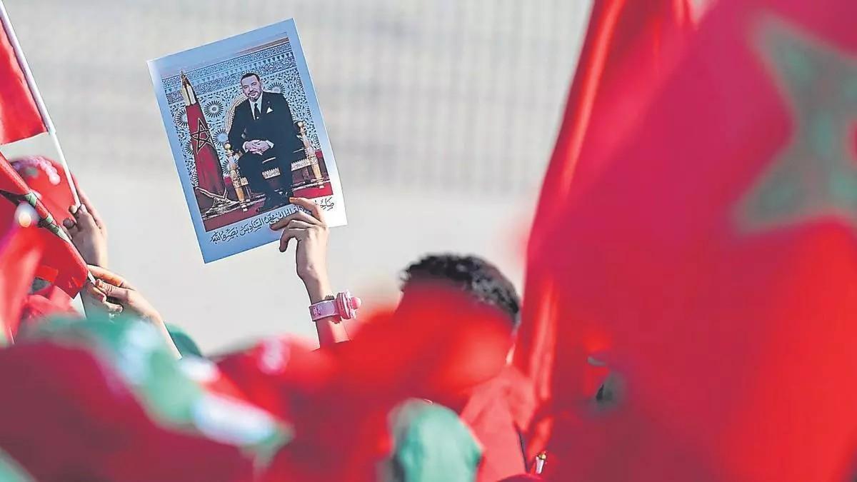 Manifestación de apoyo a la posición de Marruecos sobre el Sáhara Occidental, con asistentes portando banderas marroquíes y un retrato del rey Mohamed VI.