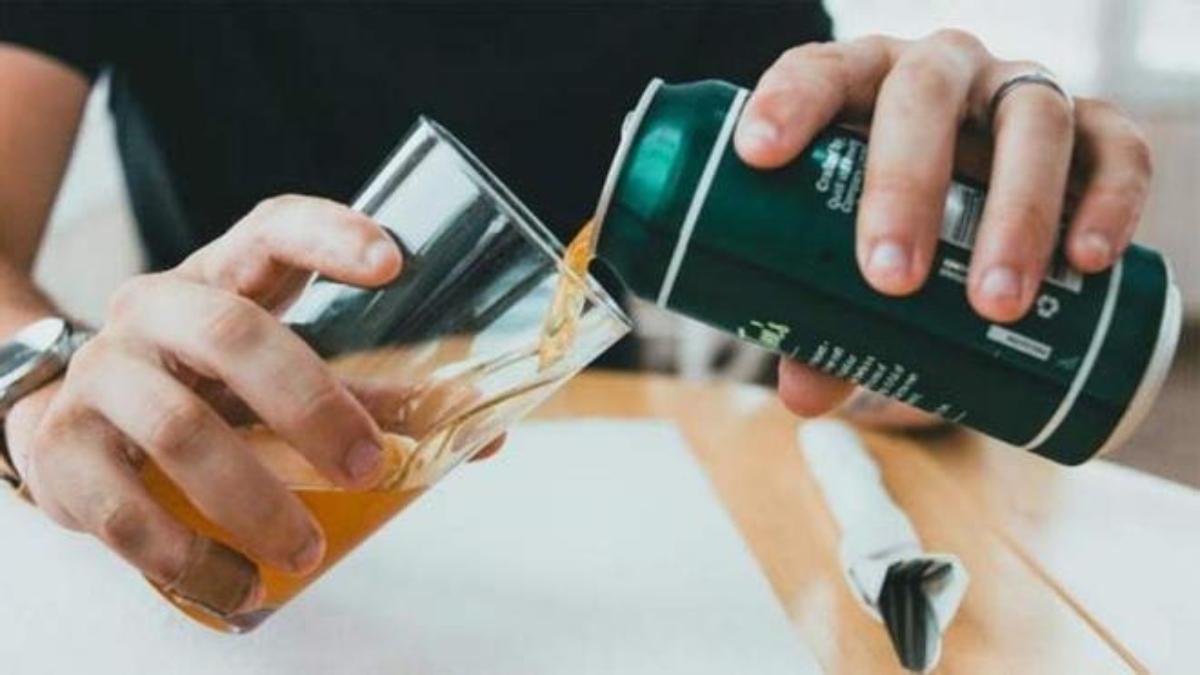 Un hombre rellena un vaso de cerveza.