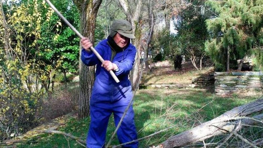 Un vecino de Valer corta leña para calentarse el próximo invierno.