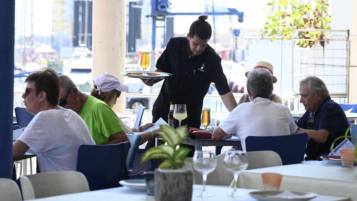Un camarero sirve unas cervezas a unos clientes en la terraza de una cafetería de Castelló.