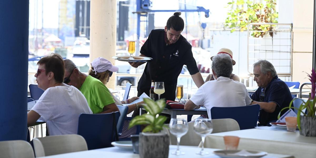 Un camarero sirve unas cervezas a unos clientes en la terraza de una cafetería de Castelló.