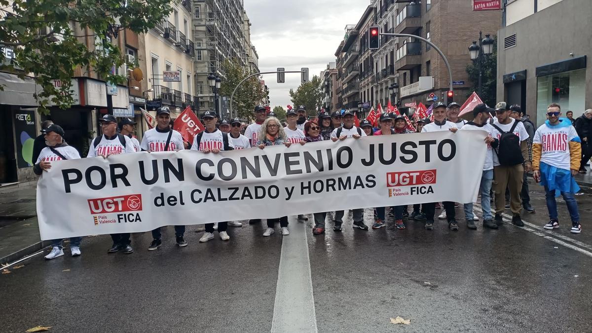 Representantes alicantinos de UGT con una pancarta sobre el calzado.