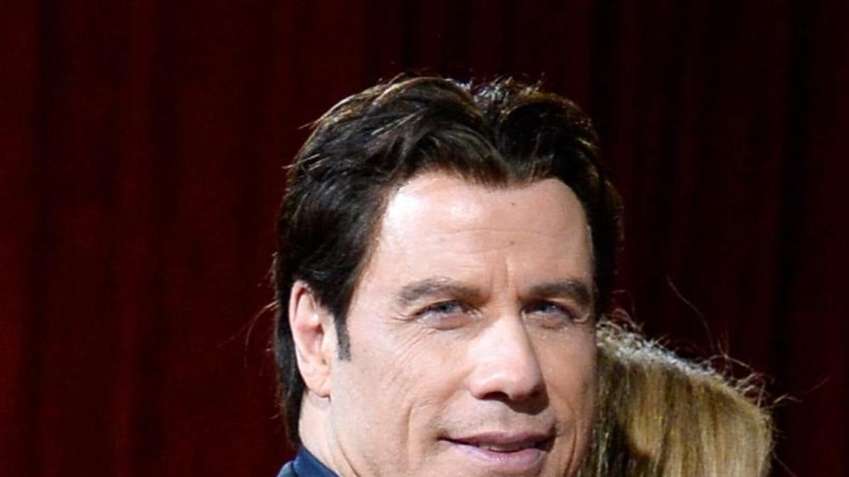 John Travolta con traje y camisa azul