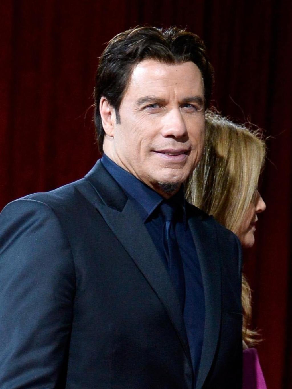 John Travolta con traje y camisa azul
