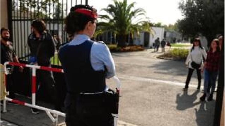 Una agent dels Mossos d&#039;Esquadra vigila la porta d&#039;entrada al cementiri de Figueres, ahir.