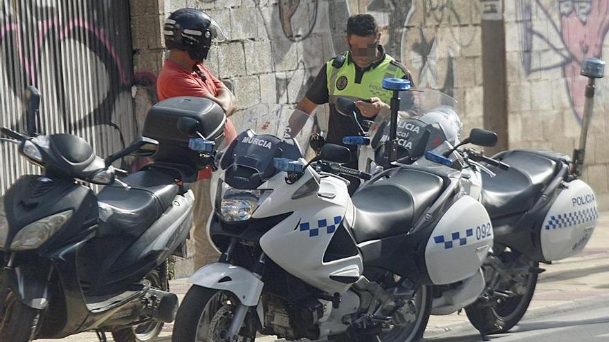 Un agente de la Policía Local de Murcia impone una sanción a un ciudadano que circulaba en una moto.